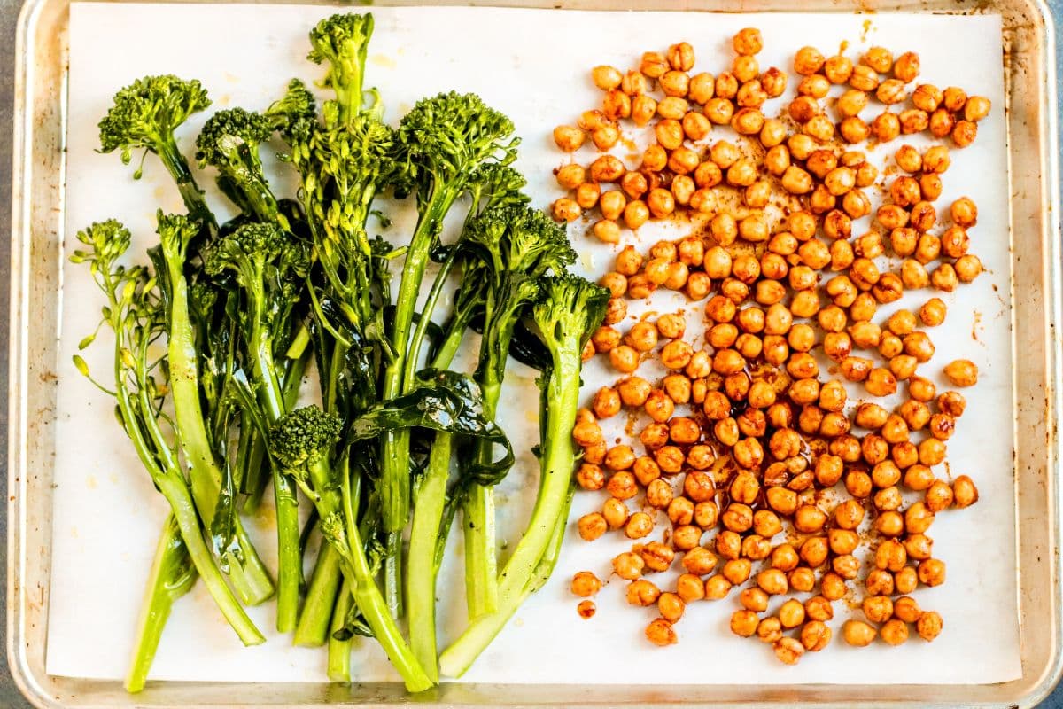 Broccolini and chickpeas on a baking sheet.
