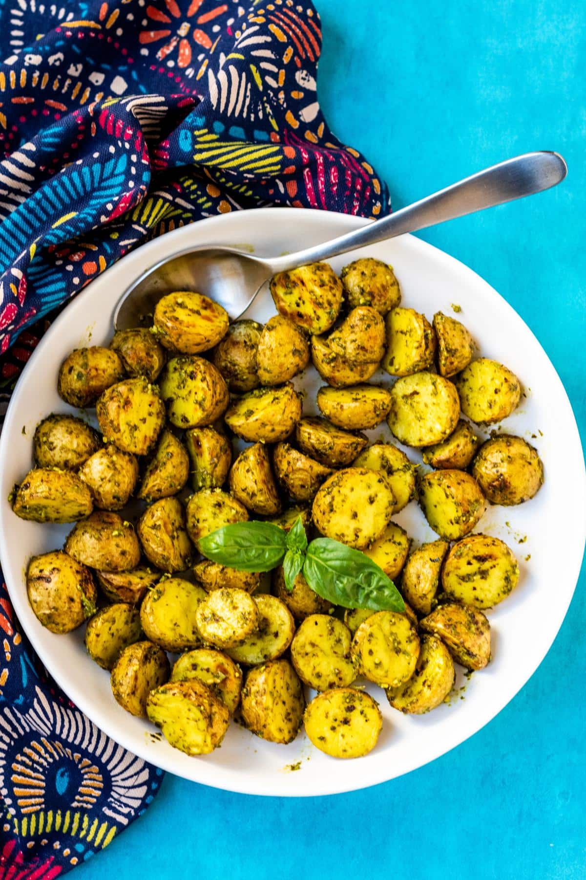 Serving bowl of Vegan Pesto Potatoes with a colorful napkin.