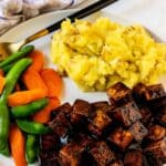 Dinner plate with balsamic tofu, mashed potatoes, and steamed sugar snap peas and carrots.