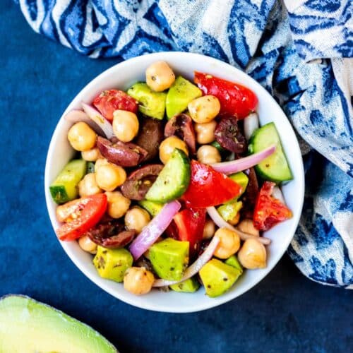 Bowl of California Greek Chickpea Salad and a blue and white napkin.