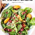 Bowl of salad with text overlay: Pomegranate Spinach Salad.