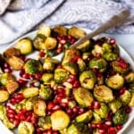 The roasted vegetables on a serving platter with a spoon.