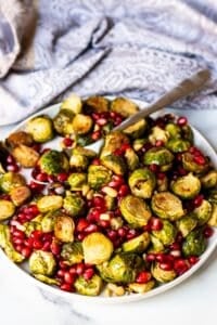 The roasted vegetables on a serving platter with a spoon.