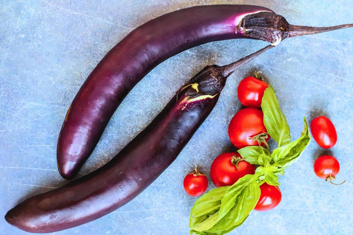 Japanese eggplants, cherry tomatoes, and fresh basil leaves.