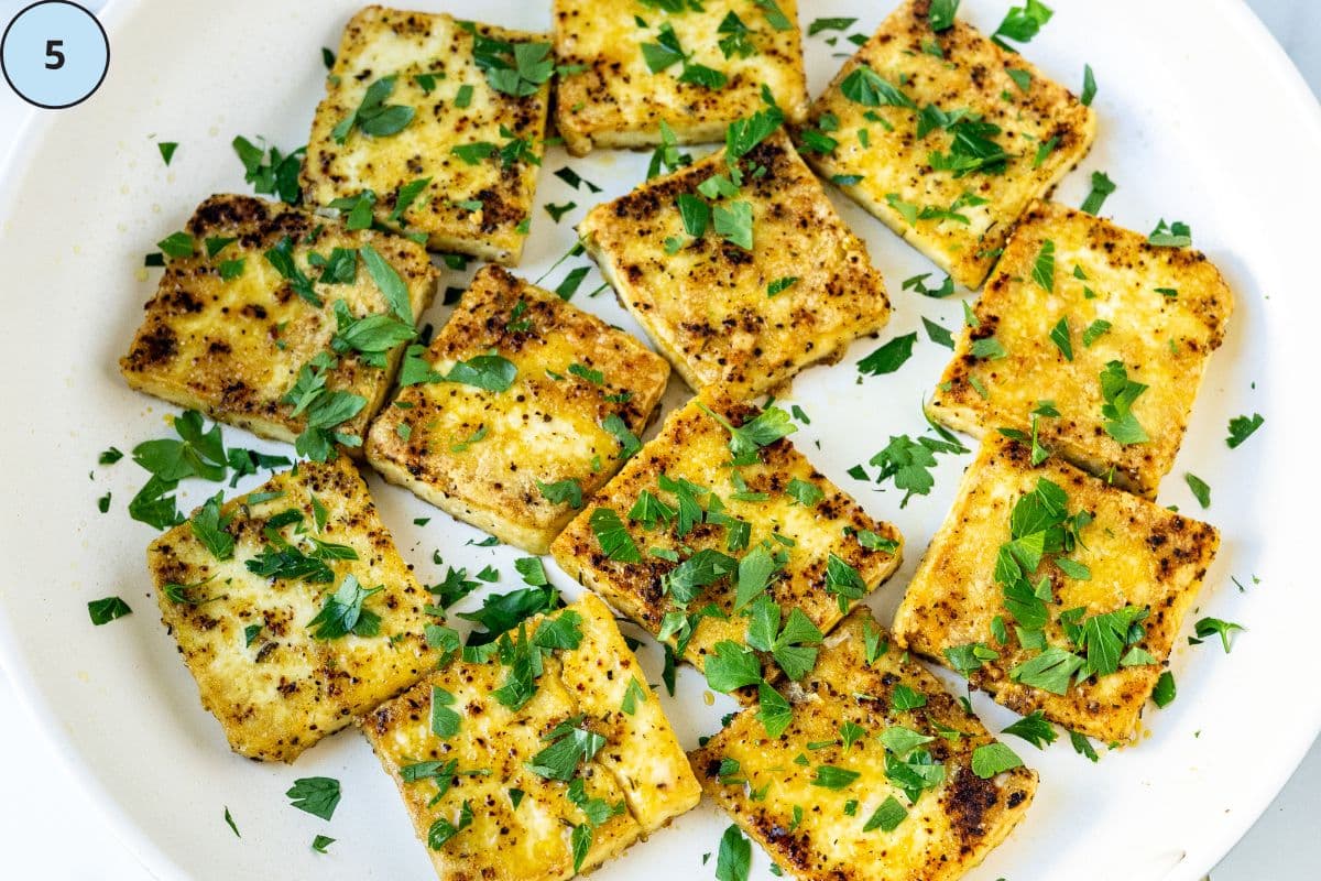 The cooked tofu in a skillet garnished with fresh parsley.