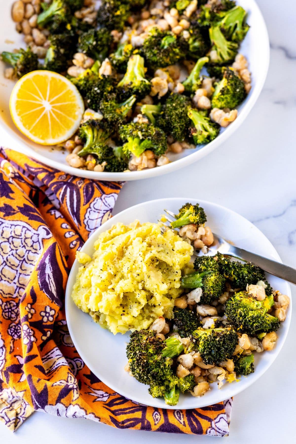 A dinner plate with mashed potatoes and roasted broccoli and white beans.