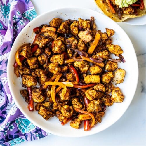 Baked tofu and bell peppers fajitas in a serving bowl.