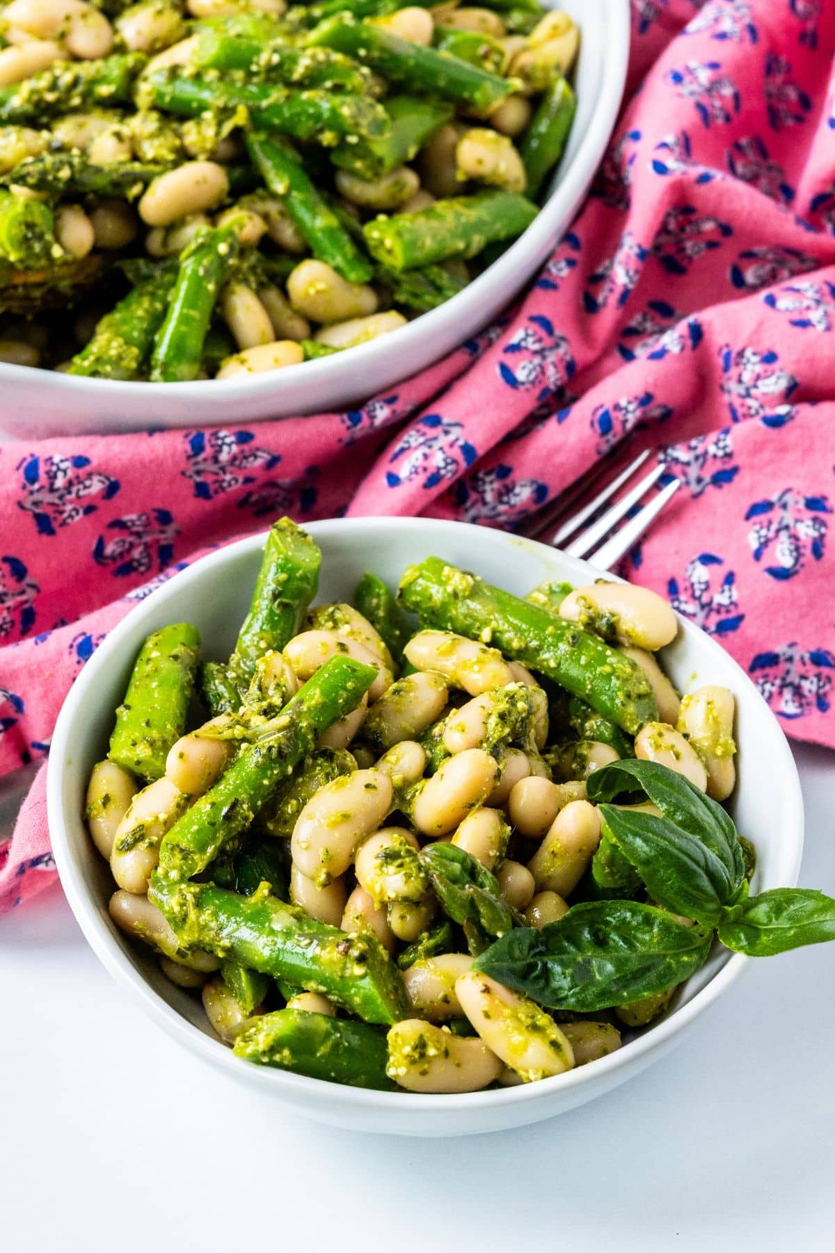 A serving of salad in a small bowl with the serving bowl in the background.