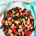 Kale salad with avocado, strawberries, and walnuts.