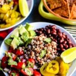 Bowl with quinoa, black beans, cherry tomato salsa, avocado, and jalapenos, with text overlay: Quinoa Burrito Bowls with Black Beans.